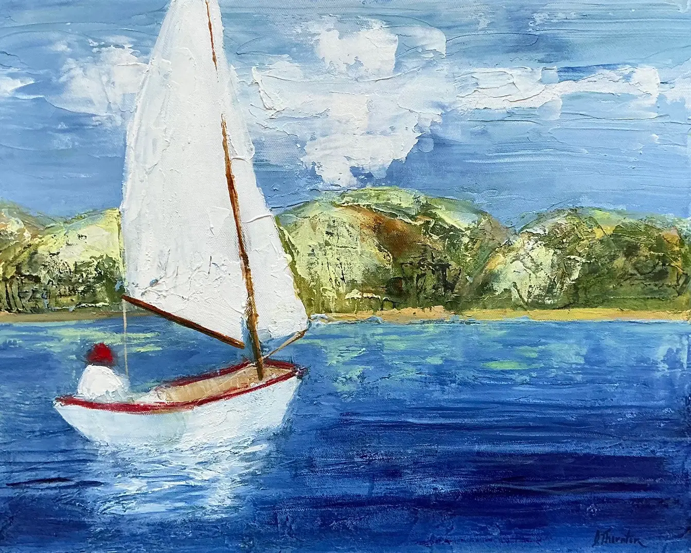 sailboat on blue water with green landscape in background